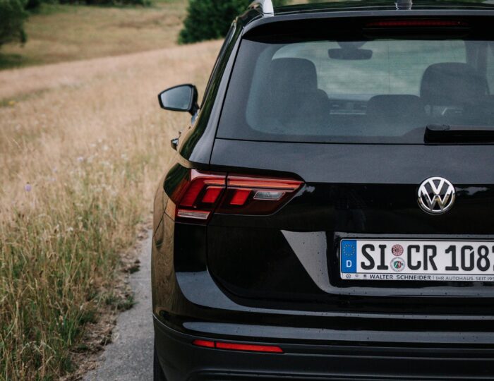 Heckansicht eines VW Tiguans auf einer Landstraße | Autovermietung Siegen